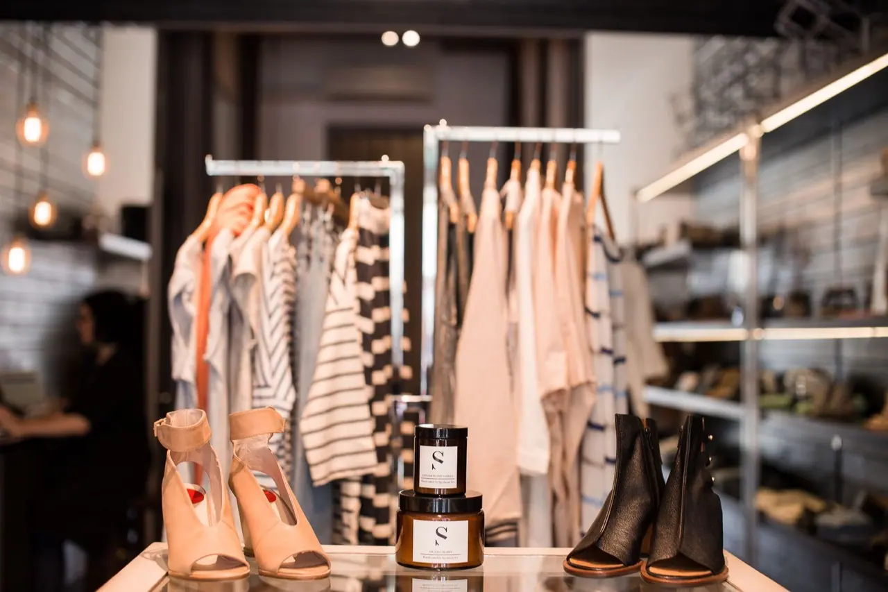 Clothing and shoes displayed on racks in a boutique store